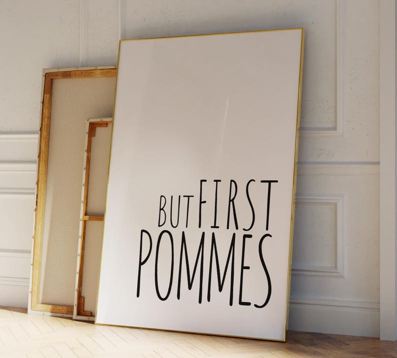 Może przedstawiać: Biały plakat w złotej ramie z napisem "But first pommes" czarnymi literami.