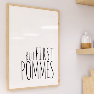 Może przedstawiać: Wydruk w ramie z tekstem "But first, pommes" czarnymi literami na białym tle.