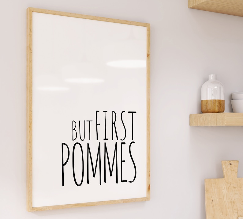 Może przedstawiać: Wydruk w ramie z tekstem "But first, pommes" czarnymi literami na białym tle.