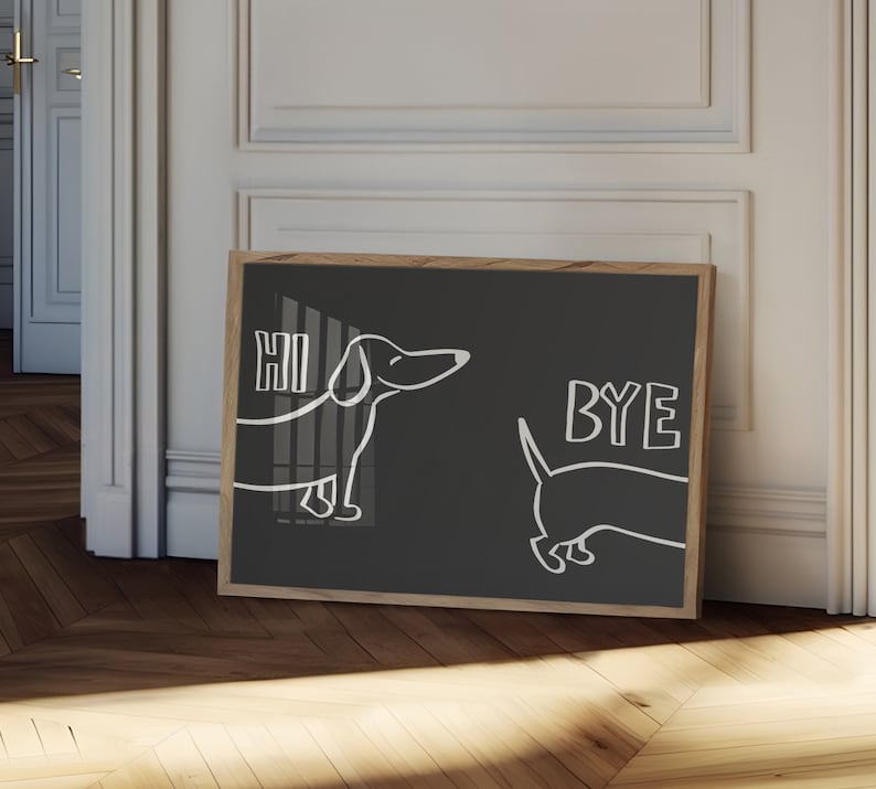 May include: A black framed print with a white outline of two dachshunds. The dachshund on the left says "HI" and the dachshund on the right says "BYE".