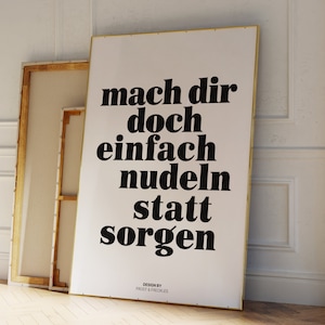 Pu&ograve; includere: Un poster bianco con testo nero che recita "mach dir doch einfach nudeln statt sorgen" e il testo "DESIGN BY FROST & FRECKLES" in basso.