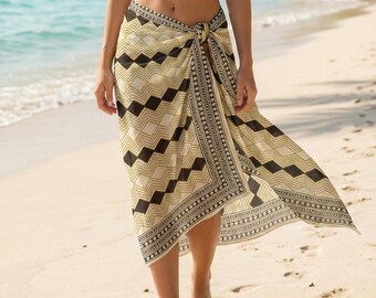May include: A woman wearing a white bikini top and a beige and black patterned sarong tied at the waist. The sarong features a geometric design. The background shows a beach with palm trees and the ocean.