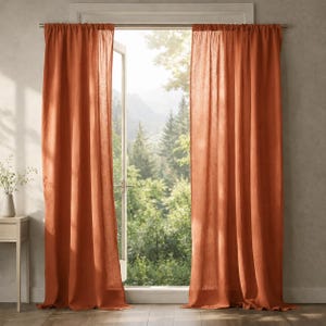 Può includere: Tende di lino color ruggine appese a un'asta d'argento che incorniciano una finestra aperta. Le tende sono drappeggiate e strutturate, con la luce del sole che filtra attraverso la finestra, rivelando una foresta verde e montagne. Arredamento per la casa.