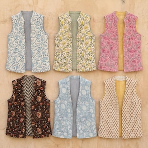 May include: Six reversible vests with floral and geometric patterns. The vests feature various color combinations, including blue, pink, yellow, and brown. Each vest has a different pattern on the front and back, with a striped or patterned interior.