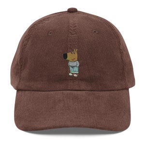 Può includere: Un cappello da baseball in velluto a coste marrone con un cane di cartone animato ricamato che indossa una camicia blu e pantaloni marroni.
