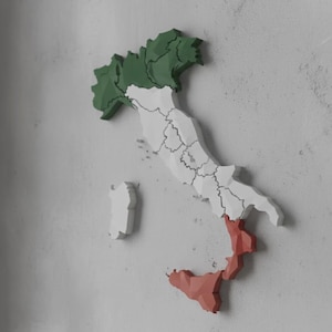 Puede incluir: Un mapa de madera tridimensional de Italia, pintado con los colores de la bandera italiana. La región norte es verde, la región central es blanca y la región sur es roja. El mapa está montado en una pared texturizada de color gris claro.