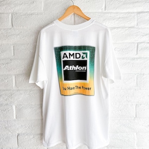 May include: A white short-sleeve t-shirt featuring a large graphic on the back. The graphic displays the AMD Athlon Processor logo in black, white, and green, with a yellow gradient background and the text "You Have The Power" printed below.