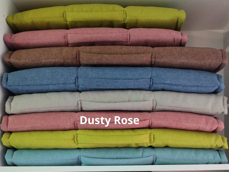 Peut inclure: Une pile de dix housses de coussin dans diff&eacute;rentes couleurs, dont rose poudr&eacute;, vert, bleu et gris. Les coussins sont faits d'un tissu doux et textur&eacute; et ont une forme rectangulaire simple.