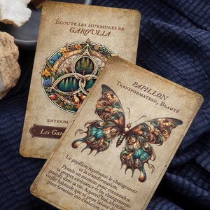 May include: Two tarot cards with vintage-style illustrations. One card features a detailed butterfly design with teal, brown, and orange hues. The other card has a circular design with a forest scene. Text includes "PAPILLON" and "GAROULIA".