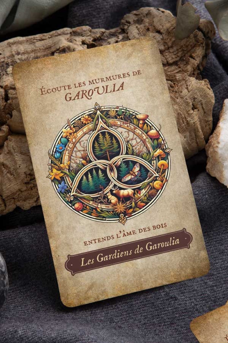 May include: A vintage-style card with the text "&Eacute;coute les murmures de Garoulia" and a circular illustration featuring trees, a deer, a butterfly, and mushrooms. The card has a brown border and is set against a gray background.