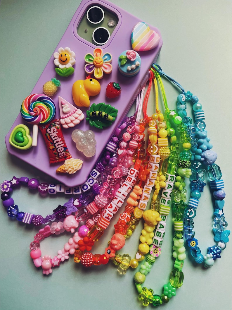 Six colorful beaded phone straps attached to a purple phone case