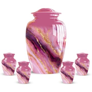 May include: A collection of pink and purple cremation urns with a marbled design and gold accents. The set includes a large urn and five smaller keepsake urns, all with matching lids. The urns are designed with a glossy finish.