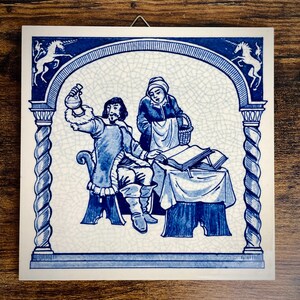 May include: Square ceramic tile with a blue and white illustration of two people in a historical scene. The tile features an arched border with unicorns and decorative columns. The central image depicts a person holding a flask and another person with a basket.