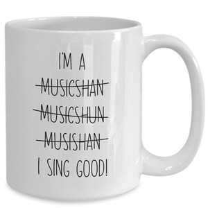 May include: White ceramic coffee mug with black text that reads "I'm a musician I sing good!" with the word "musician" crossed out multiple times.