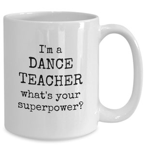 May include: White ceramic coffee mug with black text that reads "I'm a DANCE TEACHER what's your superpower?"