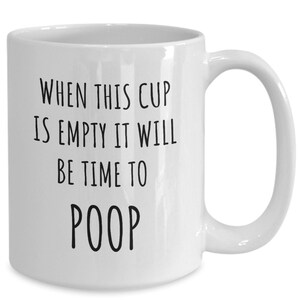 May include: White ceramic coffee mug with black text that reads "When this cup is empty it will be time to poop."