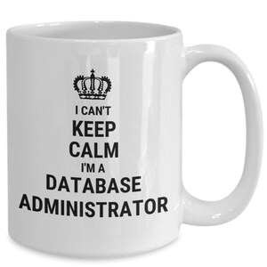 May include: White ceramic mug with a black crown and the text "I can't keep calm I'm a database administrator".