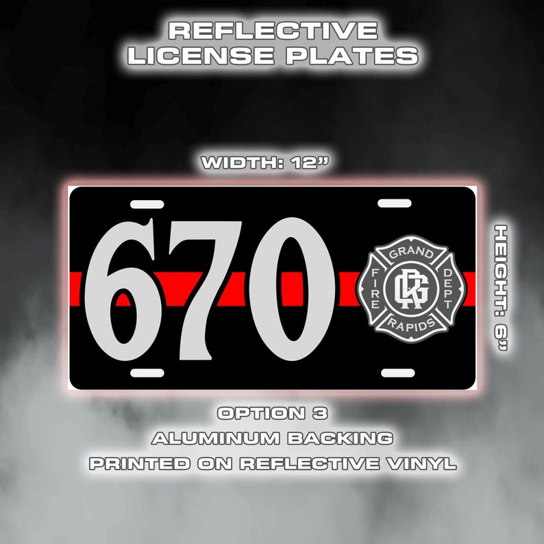 May include: Black license plate with white "670" and a red stripe. Features the Grand Rapids Fire Dept. logo. Plate dimensions are 30.5 cm wide and 15.2 cm high.