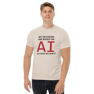 May include: A beige t-shirt with the text "My decisions are based on AI (Alcohol Influence)" printed on the front. The text "AI" is in red.