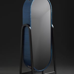 May include: A tall, oval-shaped mirror with a blue wooden frame and a black metal stand. The mirror is freestanding and has a modern design.