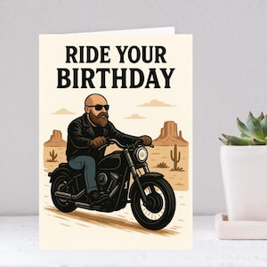 May include: Greeting card with the text "RIDE YOUR BIRTHDAY" above an illustration of a person riding a black motorcycle. The background features a desert landscape with cacti and rock formations. The person is wearing sunglasses and a black leather jacket.