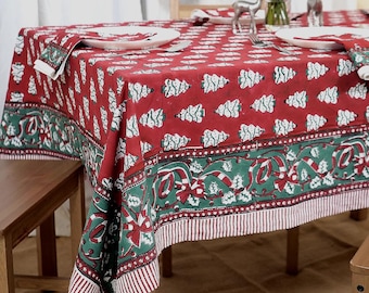 May include: A rectangular tablecloth featuring a red background with a repeating white Christmas tree pattern. The border is a wide green band decorated with red and white candy canes, holly leaves, and berries, finished with a red and white striped edge.