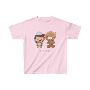 May include: Pink children's t-shirt with a cartoon hedgehog and bear wearing a hat. The text "Best Friends!" is printed below the image.