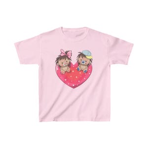 May include: Pink children's t-shirt with a graphic of two cartoon hedgehogs sitting on a red heart with white polka dots. The hedgehog on the left is wearing a pink bow and the hedgehog on the right is wearing a blue hat.