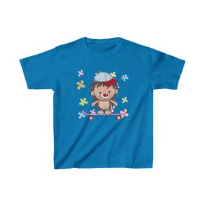 May include: A blue youth t-shirt with a cartoon hedgehog wearing a red and white baseball cap and riding a pink skateboard. The hedgehog is surrounded by colorful flowers.