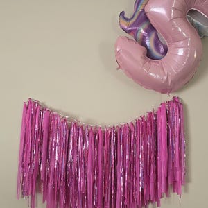 Backdrop/garland fringe made with pink plastic cloth and laser metallic streamers. Perfect for parties, celebrations & decorating office