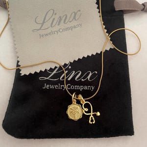 Halsband med ormkedja i guld, 50 cm, med guldfärgade berlocker för legitimerad sjuksköterska och stetoskop