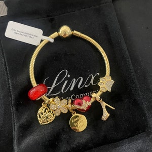 Linx Yellow Gold Snake Chain Bracelet with Gold Silver and Red Charms