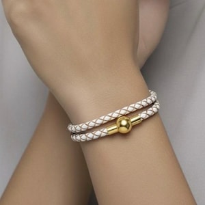 Pulsera Linx de cuero trenzado blanco con cierre magnético fácil de usar en oro amarillo.