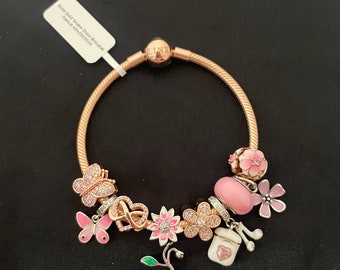 Pulsera Linx de oro rosa con cadena de serpiente y dijes en tonos rosas.
