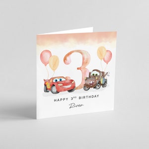May include: A birthday card with a watercolor illustration of the number 3, two cartoon cars, and balloons. The text reads "Happy 3rd Birthday River".