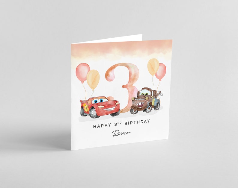 May include: A birthday card with a watercolor illustration of the number 3, two cartoon cars, and balloons. The text reads "Happy 3rd Birthday River".