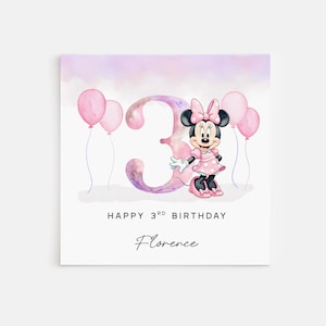 Peut inclure: Une carte d'anniversaire carrée avec un grand chiffre 3 aquarelle, Minnie Mouse en robe rose à pois et quatre ballons roses. Le texte indique HAPPY 3RD BIRTHDAY et le prénom Florence en police cursive noire sur fond blanc.