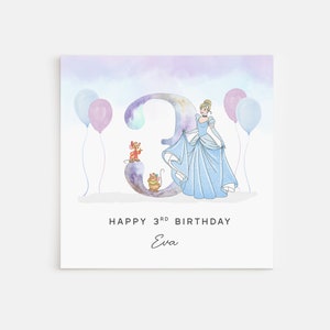 May include: A square birthday card featuring Cinderella in a blue gown next to a large number 3. Two mice are on the number 3. The card has the text "Happy 3rd Birthday Eva" and includes two pink and two blue balloons.
