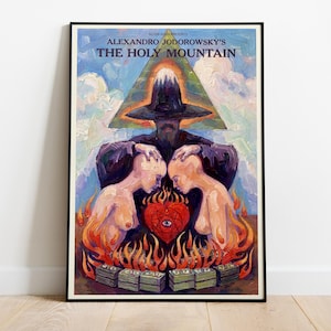 May include: A framed art print featuring the text "ALEXANDRO JODOROWSKY'S THE HOLY MOUNTAIN." The artwork depicts a surreal scene with figures, flames, and a pyramid. The color palette includes blues, oranges, and purples.