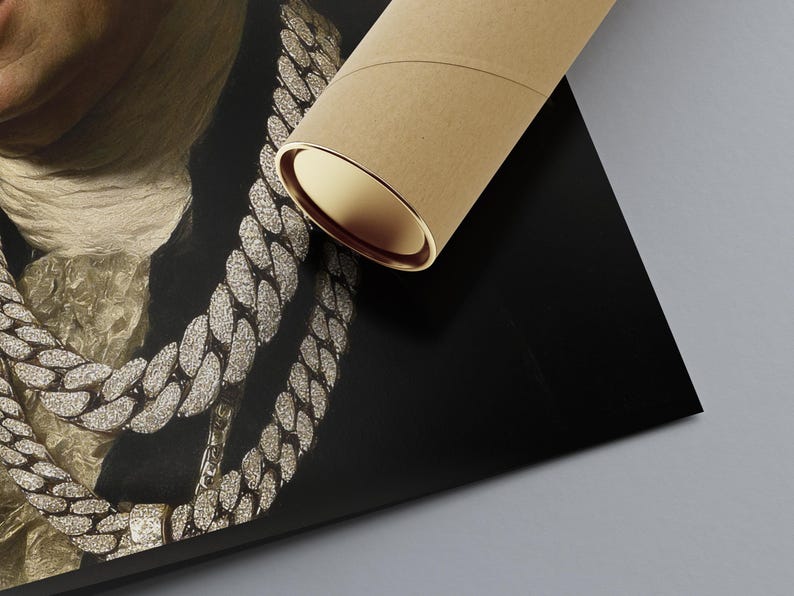 May include: A rolled brown cardboard mailing tube resting on a printed poster. The poster features a close-up of a person wearing multiple thick, silver-toned, diamond-encrusted cuban link chains over a dark jacket and a textured white neck scarf.