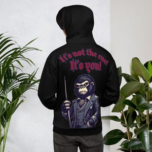 May include: Black hoodie featuring a graphic of a gorilla in a suit holding a snooker cue. The text "It's not the cue! It's you!" is printed on the hoodie.