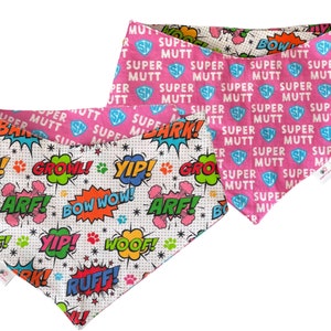 May include: Two dog bandanas. One is white with colourful comic book sound effects and paw prints. The other is pink with the words "SUPER MUTT" and a shield graphic. Both bandanas are reversible.