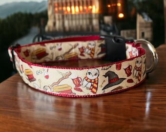 May include: A cream-colored dog collar with a repeating pattern of owls, hats, and other magical icons. The collar has a burgundy trim and a black plastic buckle with a silver metal loop.