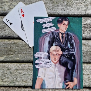May include: An illustration featuring two playing cards, an Ace of Spades and an Ace of Hearts, next to a painting. The painting depicts two figures with speech bubbles containing text. The figures are in a dark suit and a white shirt.