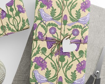 May include: Gift-wrapped presents with floral and bird-themed wrapping paper. The paper features purple flowers, green leaves, and light purple birds on a cream background. Each gift is tied with twine and a white tag. A ball of twine, scissors, and tags are also visible.