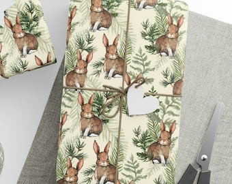 May include: A set of three gift wrapping papers featuring a repeating pattern of brown rabbits and green pine branches on a cream background. The papers are tied with twine and decorated with white paper stars and hearts.