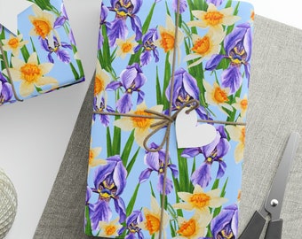 May include: Three gift boxes wrapped in blue and green floral patterned paper with white gift tags. The paper features a watercolor design of purple irises and yellow daffodils.
