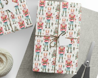 May include: Three gift boxes wrapped in white paper with a repeating pattern of nutcracker soldiers and Christmas trees. The boxes are tied with twine and decorated with white paper stars and hearts.