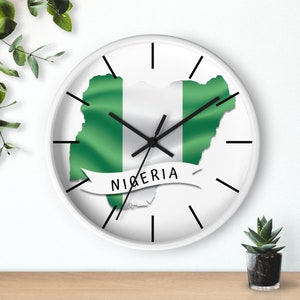 May include: White wall clock with black hands and a green and white map of Nigeria with the word "NIGERIA" on a white banner.