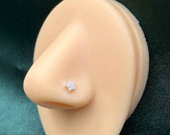 May include: A silver nose ring with a clear star-shaped stone.